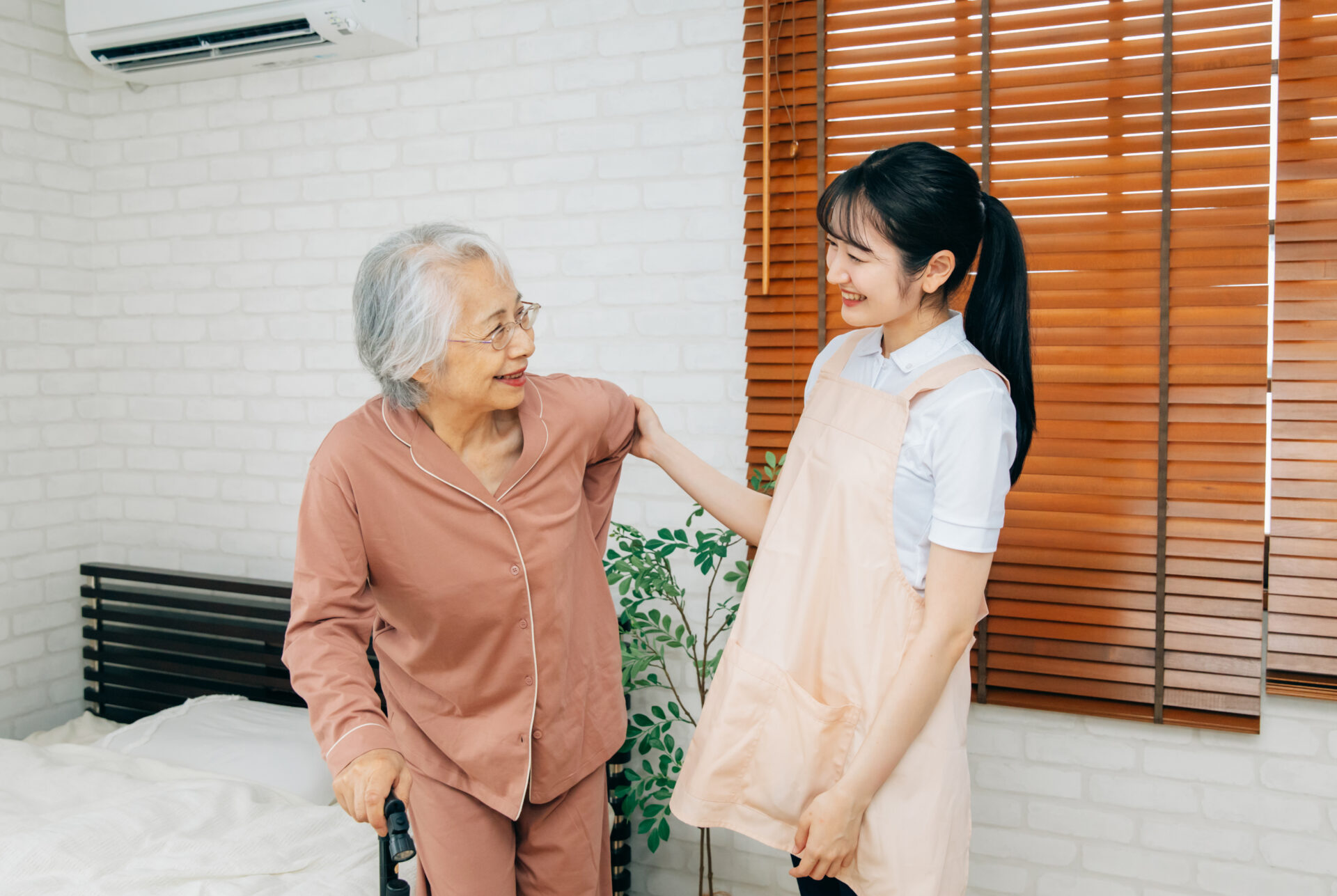 笑顔の高齢者女性と介護士の女性（訪問介護・在宅介護）